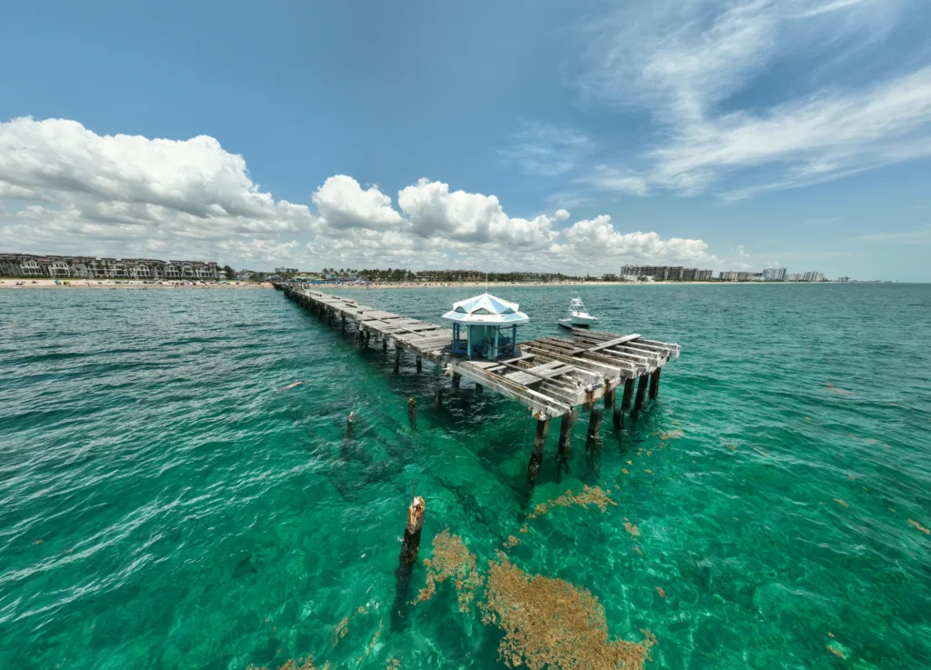 Pier extending into green coastal water