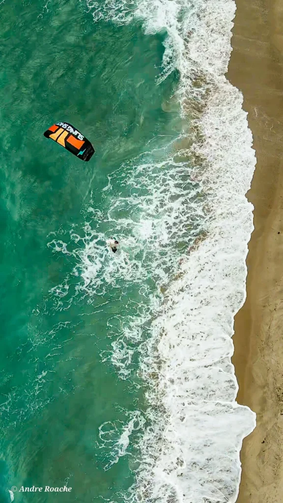 Overhead view of a kiteboarder near breaking waves