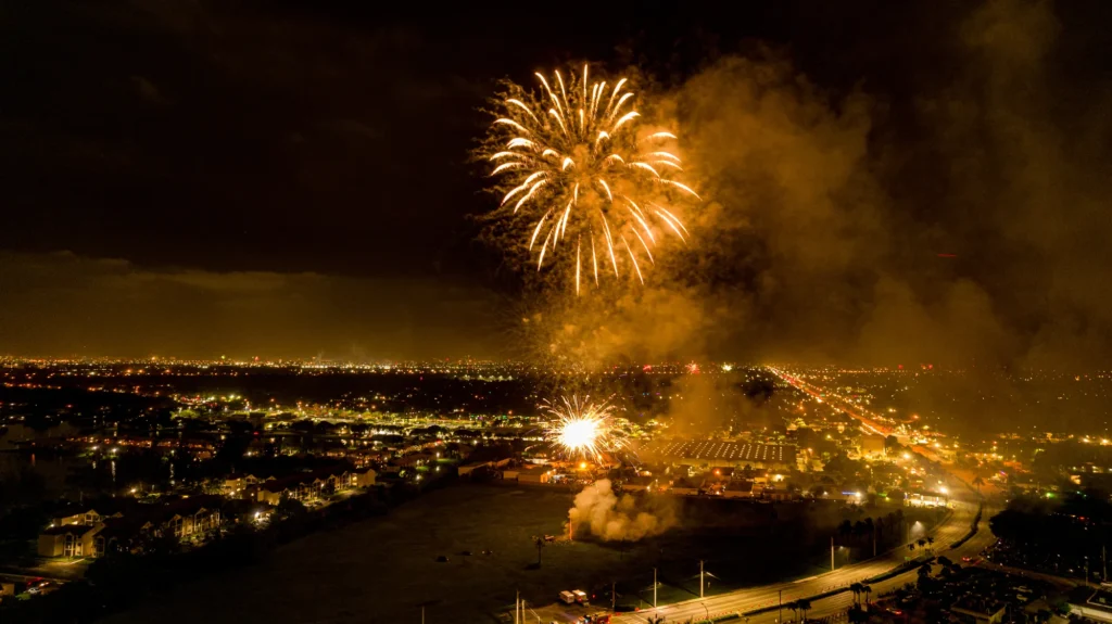 Nighttime fireworks above a waterfront setting