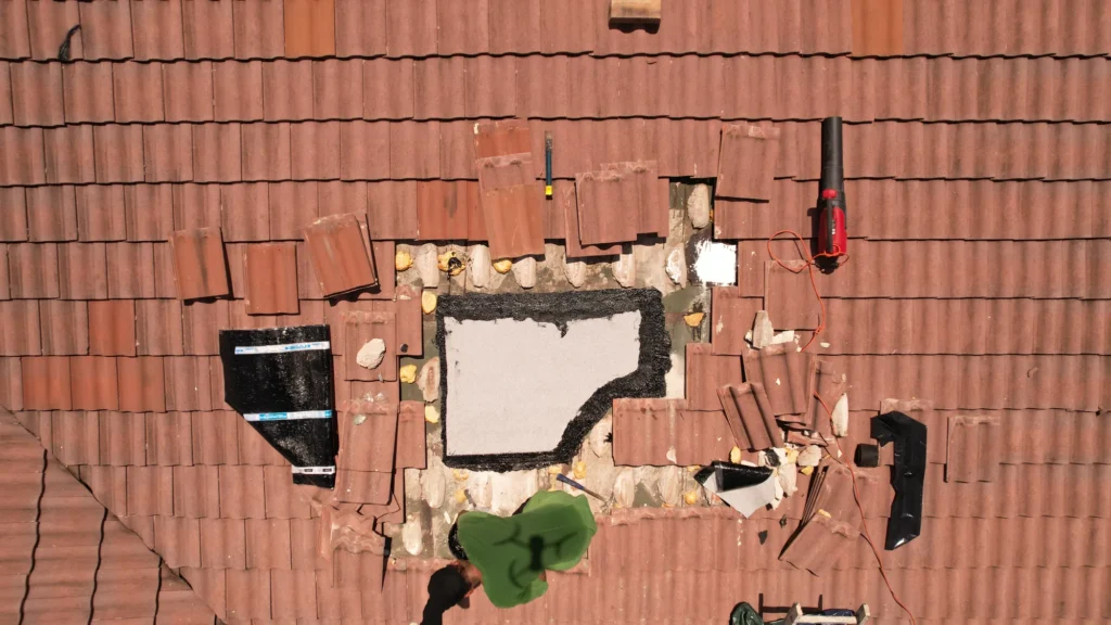 Worker and repair materials on a tiled roof