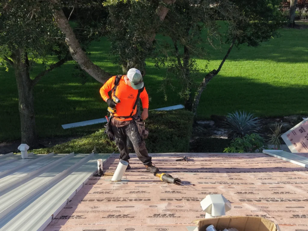 Worker installing metal roof panels